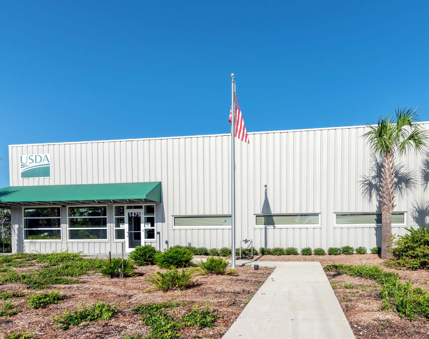 Front View of U.S. Department of Agriculture Building with Flag Pole and Landscaping